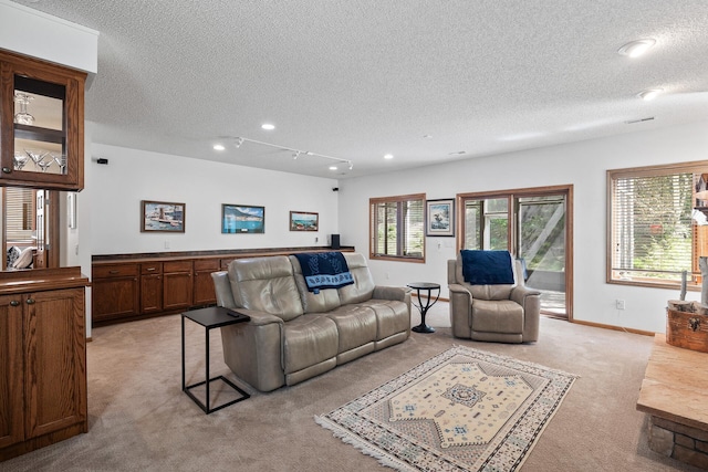 living area with light carpet, a textured ceiling, recessed lighting, and baseboards