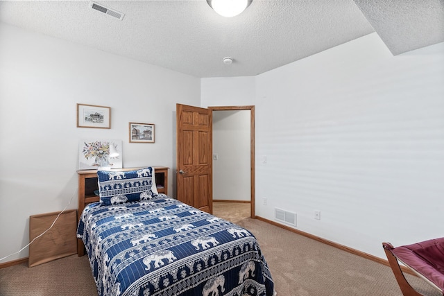 bedroom with light colored carpet, a textured ceiling, and baseboards