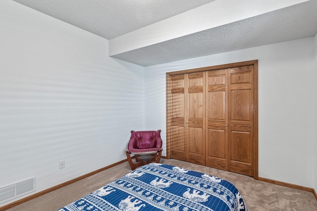carpeted bedroom featuring baseboards and a textured ceiling