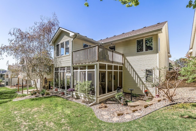 back of house with a balcony, a sunroom, and a lawn