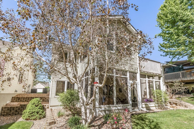 back of property featuring a balcony, a sunroom, and central AC