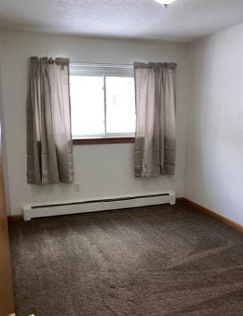 7673 River Rd, Fridley, MN 55432 - empty room featuring a baseboard heating unit, carpet flooring, and baseboards