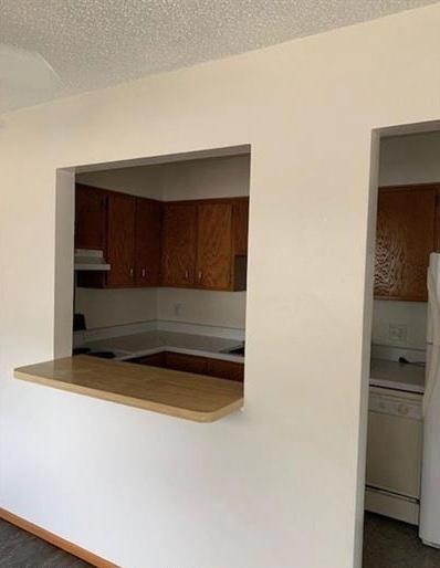 7673 River Rd, Fridley, MN 55432 - kitchen featuring white appliances, under cabinet range hood, and a textured ceiling