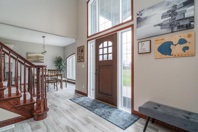 37854 210th Ave SE, Knute Twp, MN 56535 - foyer with wood finished floors, a high ceiling, baseboards, stairway, and a chandelier