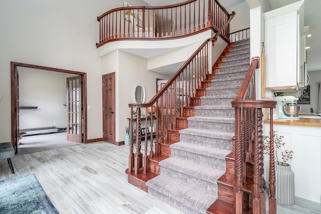 37854 210th Ave SE, Knute Twp, MN 56535 - stairway with a baseboard heating unit, wood finished floors, a high ceiling, and baseboards
