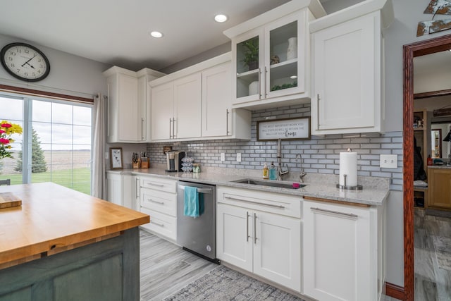 37854 210th Ave SE, Knute Twp, MN 56535 - kitchen with stainless steel dishwasher, a sink, wooden counters, backsplash, and white cabinetry