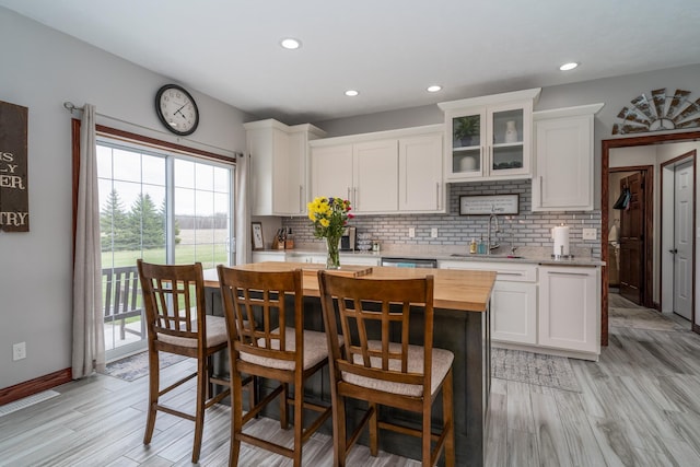 37854 210th Ave SE, Knute Twp, MN 56535 - kitchen with a sink, wood counters, white cabinetry, tasteful backsplash, and recessed lighting
