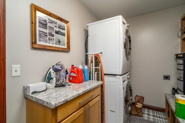 37854 210th Ave SE, Knute Twp, MN 56535 - washroom with stacked washer and clothes dryer, cabinet space, and baseboards