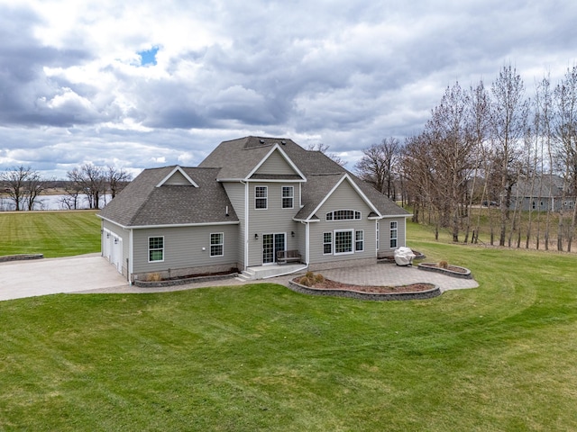 37854 210th Ave SE, Knute Twp, MN 56535 - rear view of property featuring driveway, a shingled roof, a lawn, a garage, and a patio area