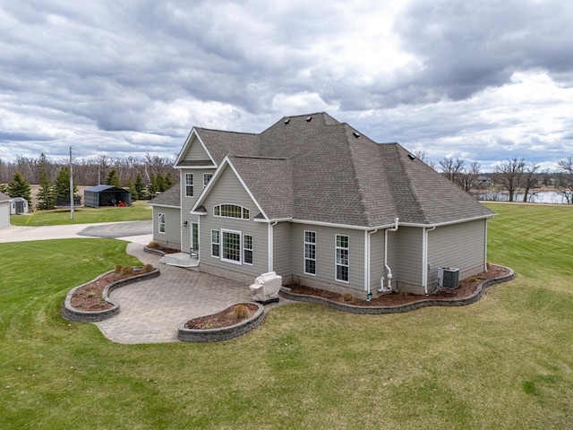 37854 210th Ave SE, Knute Twp, MN 56535 - rear view of house featuring roof with shingles, central AC unit, a lawn, and a patio