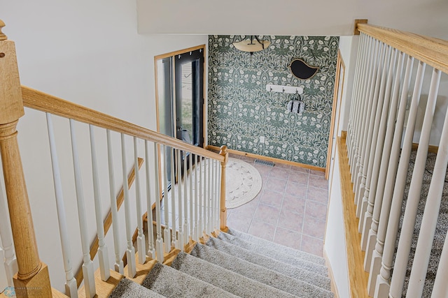 stairway with baseboards, wallpapered walls, and tile patterned flooring