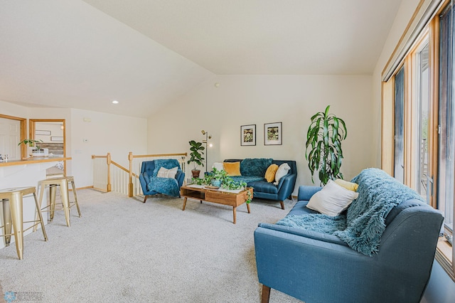 carpeted living area with lofted ceiling and baseboards