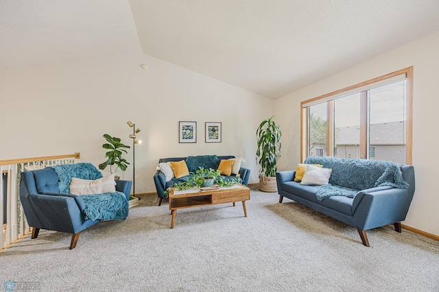 carpeted living area with lofted ceiling and baseboards