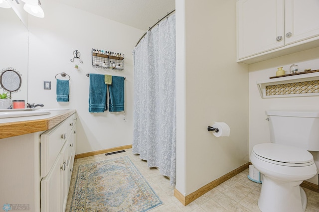 full bathroom featuring toilet, vanity, baseboards, and tile patterned flooring