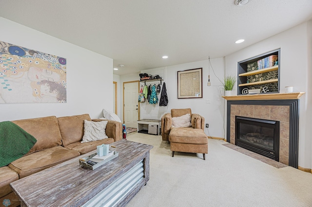 carpeted living area featuring a tile fireplace and recessed lighting