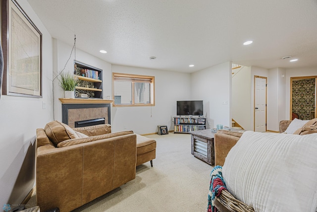 bedroom featuring light carpet, a fireplace, recessed lighting, a textured ceiling, and baseboards