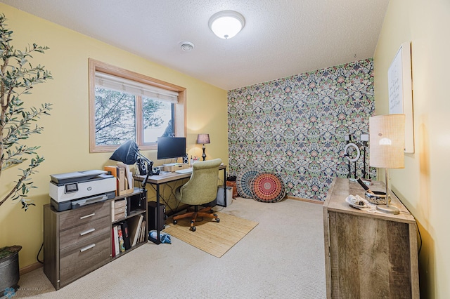 office with carpet, an accent wall, a textured ceiling, and wallpapered walls