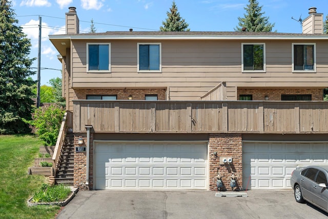 2111 Tamarin Trl, Golden Valley, MN 55427 - rear view of house featuring a chimney, driveway, and a balcony