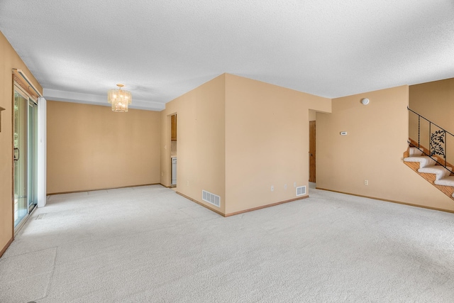2111 Tamarin Trl, Golden Valley, MN 55427 - spare room featuring stairway, a chandelier, carpet floors, baseboards, and a textured ceiling