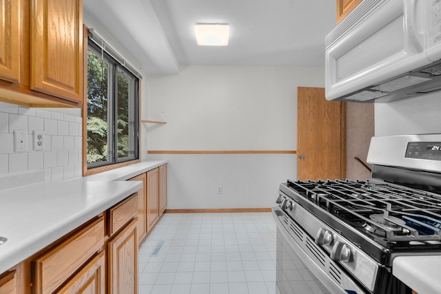 2111 Tamarin Trl, Golden Valley, MN 55427 - kitchen featuring gas range, white microwave, decorative backsplash, light countertops, and light tile patterned floors
