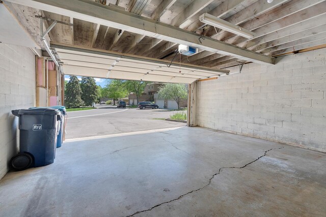 2111 Tamarin Trl, Golden Valley, MN 55427 - garage featuring a garage door opener and concrete block wall