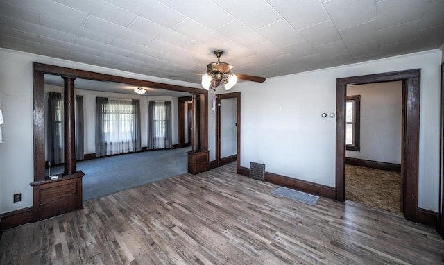 23142 Denmark Ave, Castle Rock Twp, MN 55024 - unfurnished living room with wood finished floors, baseboards, a ceiling fan, and decorative columns
