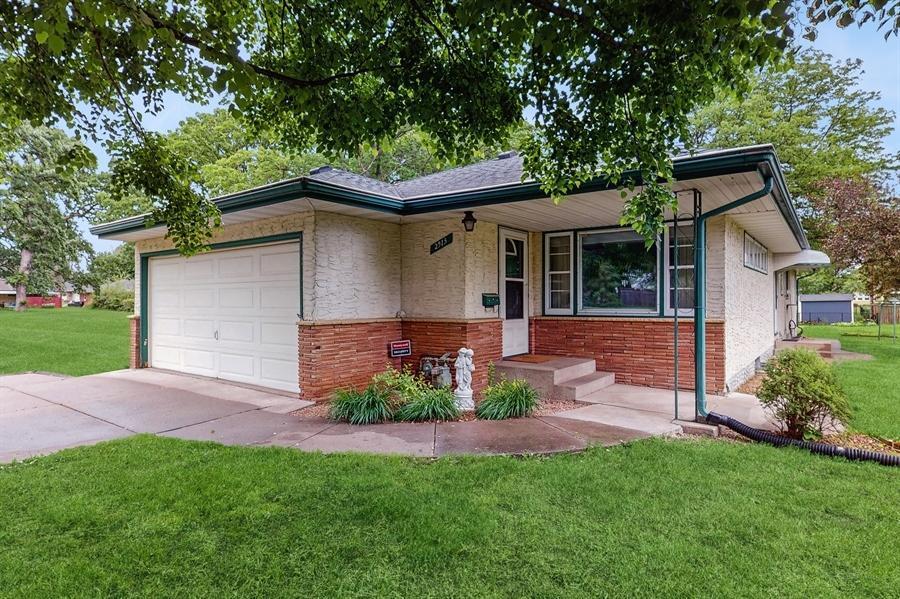 2913 Stinson Blvd, Saint Anthony, MN 55418 - ranch-style house featuring a garage, a front lawn, brick siding, and concrete driveway