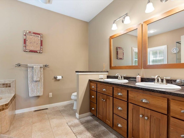 26746 County Road 4, Nisswa, MN 56468 - full bathroom featuring tile patterned floors, baseboards, double vanity, toilet, and tiled tub