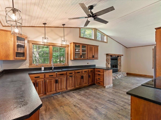 26746 County Road 4, Nisswa, MN 56468 - kitchen featuring a sink, brown cabinets, dark countertops, a peninsula, and ceiling fan