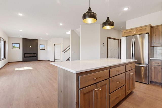 21346 Cottonwood St NW, Oak Grove, MN 55011 - kitchen with freestanding refrigerator, a center island, light wood-style flooring, recessed lighting, and pendant lighting