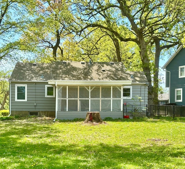 back of property with a sunroom and roof with shingles