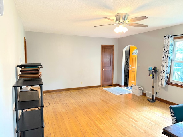 1429 Circle Dr, Albert Lea, MN 56007 - unfurnished room with arched walkways, ceiling fan, baseboards, and light wood-style floors
