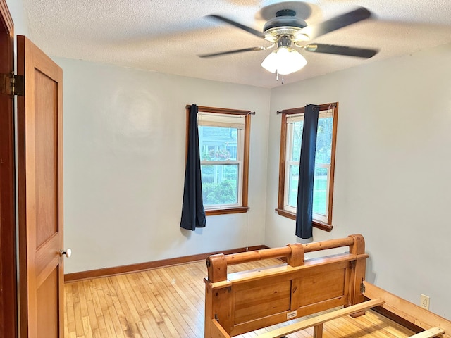 1429 Circle Dr, Albert Lea, MN 56007 - bedroom featuring light wood-style floors, baseboards, a textured ceiling, and a ceiling fan