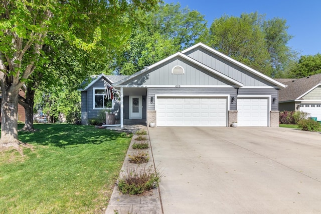 view of front of house featuring an attached garage, concrete driveway, brick siding, a front yard, and board and batten siding