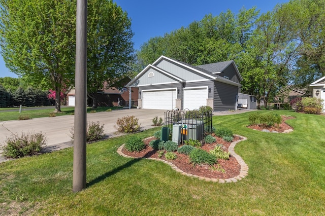 view of green lawn featuring driveway and a garage