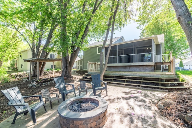 back of property featuring an outdoor fire pit, a sunroom, a patio area, and a wooden deck