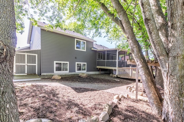 back of house with a sunroom and a deck