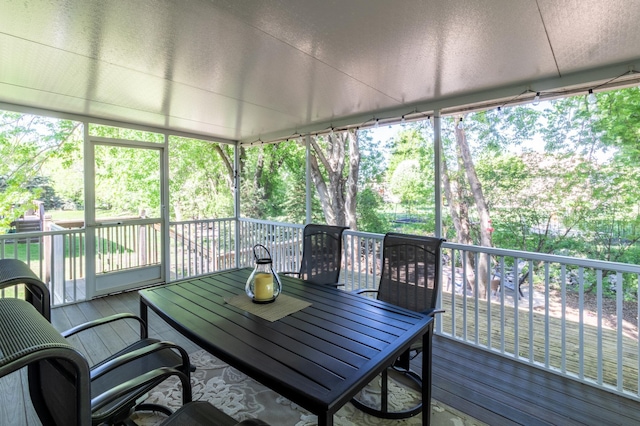sunroom with outdoor dining area and healthy amount of natural light