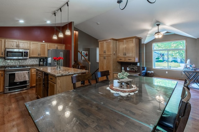 kitchen with stainless steel appliances, lofted ceiling, a ceiling fan, a kitchen island, and dark wood finished floors
