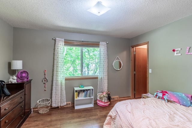 bedroom with wood finished floors and a textured ceiling