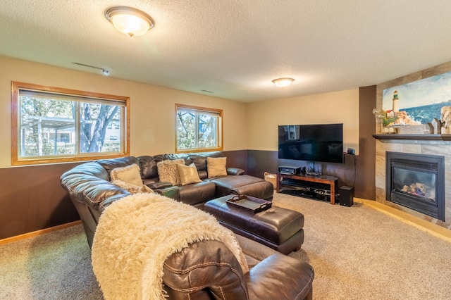 carpeted living area with plenty of natural light, a textured ceiling, and a tile fireplace