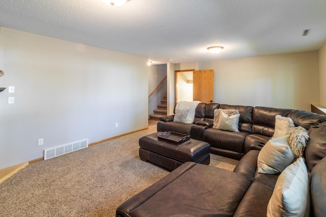 carpeted living area with stairway, baseboards, and a textured ceiling