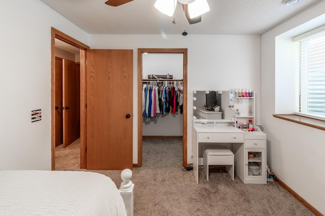 bedroom featuring light carpet, a spacious closet, multiple windows, and a closet