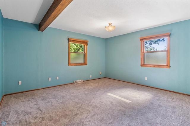 carpeted spare room with beam ceiling and baseboards