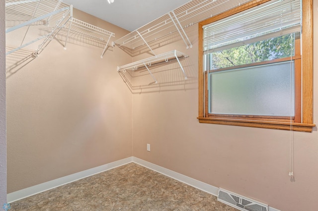 walk in closet with carpet floors