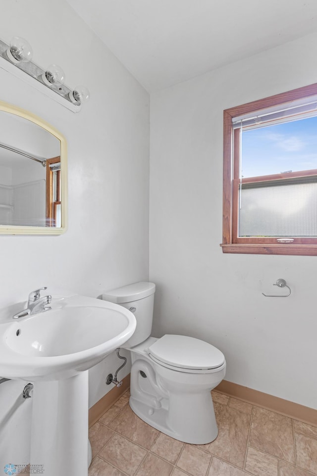 bathroom with toilet and baseboards
