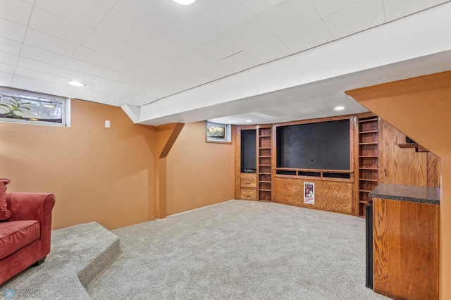 below grade area with built in shelves, carpet floors, and recessed lighting
