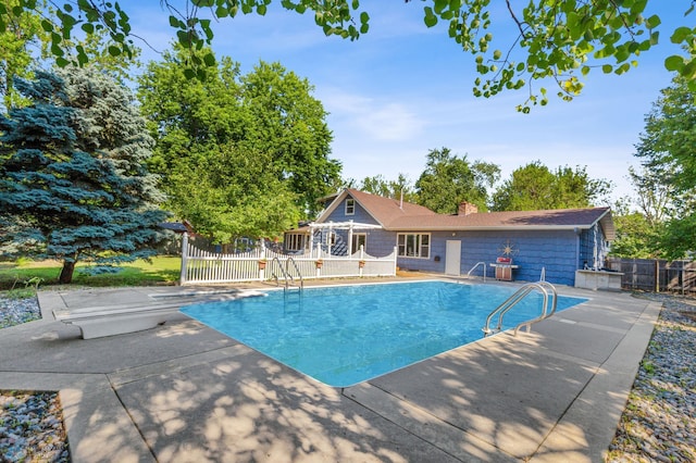 view of swimming pool featuring fence and a patio