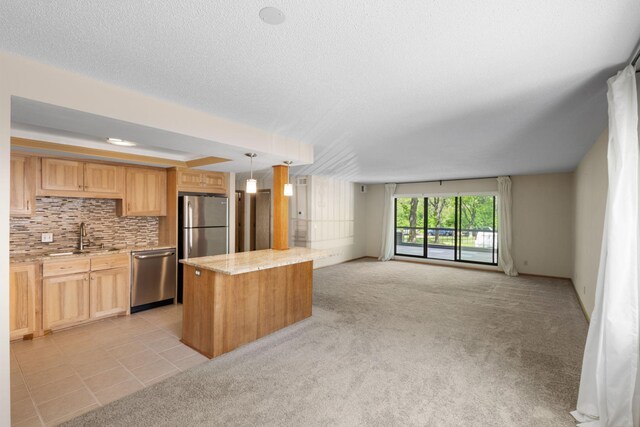 2885 Knox Ave S Unit 208, Minneapolis, MN 55408 - kitchen with stainless steel appliances, a sink, open floor plan, light brown cabinets, and decorative backsplash