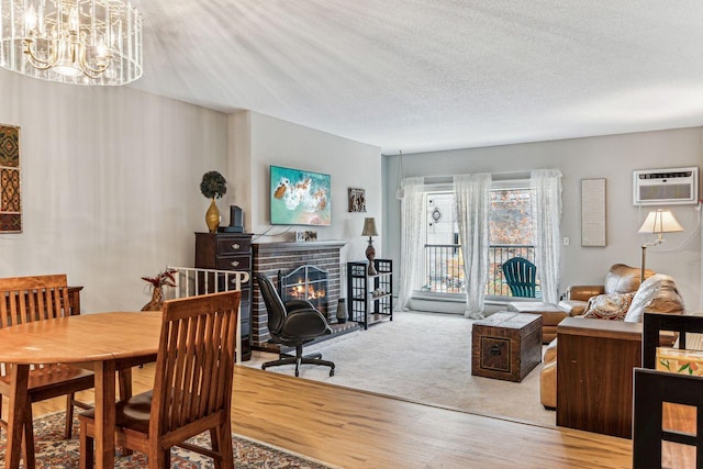 4860 Park Commons Dr Unit 309, Saint Louis Park, MN 55416 - dining area with an AC wall unit, a fireplace, a chandelier, wood finished floors, and a textured ceiling